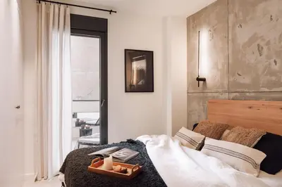 a bathroom with a shower and a toilet and a bed at Tibi - 2 bedrooms and office in Eixample Esquerra in Barcelona