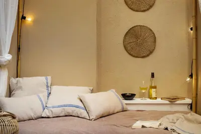 a bed with white pillows and two bottles of wine at Sahoro - 2 bedrooms and terrace in Gràcia in Barcelona