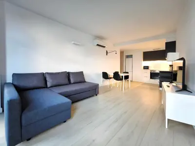 a living room with a blue couch and a kitchen at Apartamento céntrico, moderno, Terrassa Rambla in Terrassa