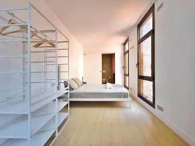 a bedroom with a bed and a glass wall at Apartamento céntrico, moderno, Terrassa Rambla in Terrassa