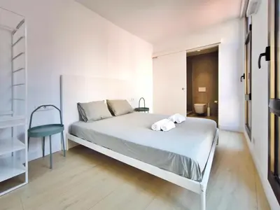 a bedroom with a bed with two towels on it at Apartamento céntrico, moderno, Terrassa Rambla in Terrassa