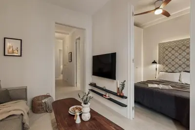 a bedroom with a bed and a tv and a mirror at Zafiro - 3 bedrooms and balcony in Sants in Barcelona