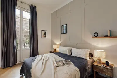 a bedroom with a large bed and a large chandelier at Halea - 3 bedrooms w/ terrace in Eixample Esquerra in Barcelona