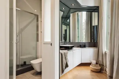 a bedroom with white walls and a bed and a mirror at Halea - 3 bedrooms w/ terrace in Eixample Esquerra in Barcelona