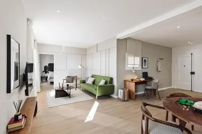 a living room with a green couch and a table at Calella - 1 bedroom and terrace in Eixample Dreta in Barcelona