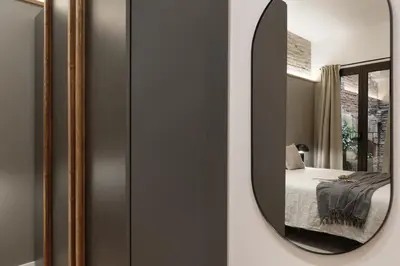 a mirror on a wall with a bed in a room at Sazos - 2 bedrooms in Sant Antoni in Barcelona