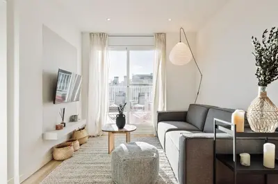 a bedroom with a white bed with gray pillows at Spiaggia - 1 bedroom and terrace in Sant Gervasi in Barcelona