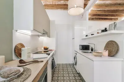 a kitchen with white walls and a wooden counter top at Scala - 2 bedrooms in Sant Gervasi in Barcelona