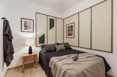 a bedroom with a bed with green and white stripes at Demir - 2 bedrooms and office in Vila de Gràcia in Barcelona