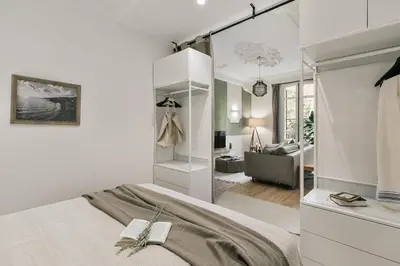 a kitchen and a living room with a couch and a table at Paestum - Studio and balcony in Eixample Esquerra in Barcelona
