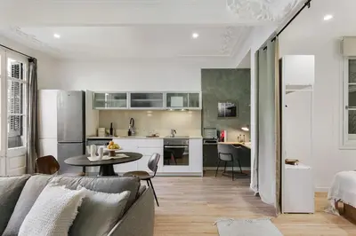 a living room with a couch and a kitchen at Paestum - Studio and balcony in Eixample Esquerra in Barcelona