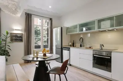 a white bedroom with a large bed and a window at Paestum - Studio and balcony in Eixample Esquerra in Barcelona