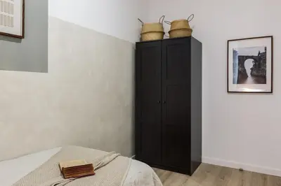 a bedroom with a black cabinet with baskets on it at Tramonti - 2 bedrooms and terrace in Sant Antoni in Barcelona