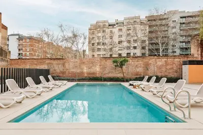 a swimming pool with lounge chairs next to a building at Marce - 3 bedrooms and a terrace in Les Corts in Barcelona