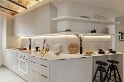 a kitchen with a counter and stools in a room at Gandoc - 3 bedrooms and terrace in Sants in Barcelona
