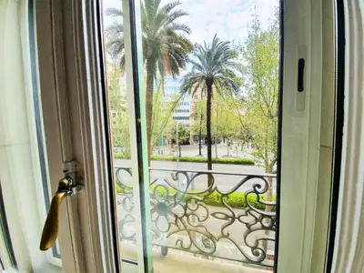 a window with a view of a palm tree at DreamKeys Barcelona City in Barcelona