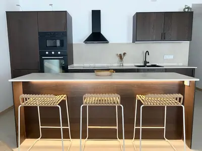 a kitchen with a counter with two stools at New penthouse duplex by the sea in Masnou