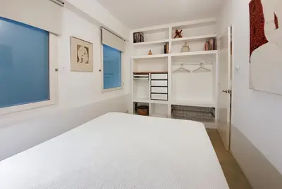 a white bedroom with a bed and a window at Flateli Rossello 134 in Barcelona