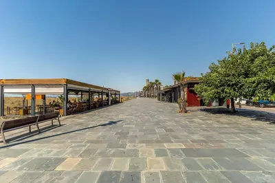 an empty street with benches and a building at Canela Homes COSTA PALMERES in Castelldefels