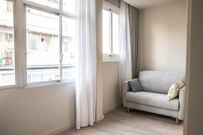 a living room with a chair and a window at Sagrada família essence in Barcelona