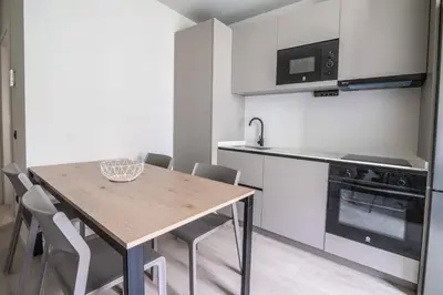 a kitchen with a wooden table with chairs and a stove at Sagrada família essence in Barcelona
