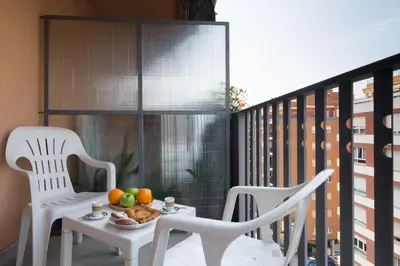 a table with fruit on a balcony with two chairs at Matarolux 2 in Mataró