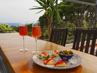 two wine glasses and a plate of food on a table at Pergola Suite - Boutique Retreat Loft Barcelona Coast Panoramic Sea View in Sant Andreu de Llavaneres