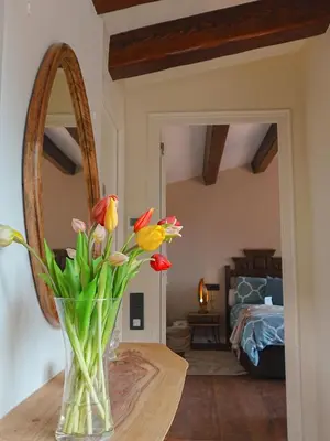 a vase with flowers on a table in a room at Pergola Suite - Boutique Retreat Loft Barcelona Coast Panoramic Sea View in Sant Andreu de Llavaneres