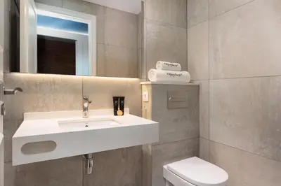 a bathroom with a white sink and a toilet at Colon Deluxe con Piscina cerca del Mar in Barcelona