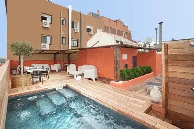 a rooftop patio with a swimming pool on a building at Colon Deluxe con Piscina cerca del Mar in Barcelona