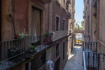 an alley with balconies and potted plants on a building at Colon Deluxe con Piscina cerca del Mar in Barcelona