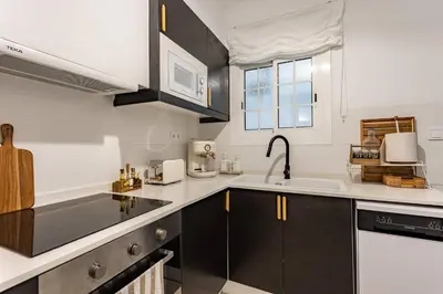 a kitchen with black and white cabinets and a sink at Barcelona Central Charm with Mediterranean Vibes in Barcelona
