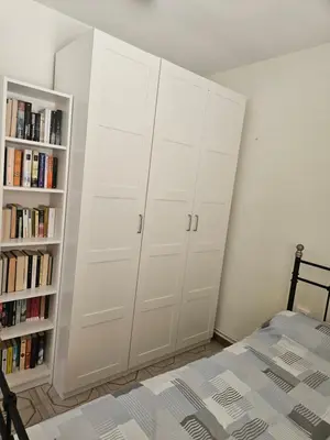 a bedroom with white cabinets and a book shelf at Apartamento Luminoso en el Centro de Sitges in Sitges