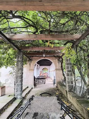 an archway with benches and a table in a building at Hostal Rural Mas Blanc in San Martín de Centellas