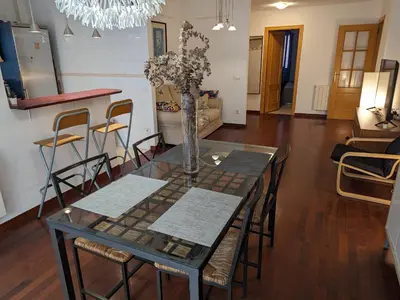 a dining room table with chairs and a vase with flowers at Large and calm 3 bedroom apartment with terrace in Barcelona