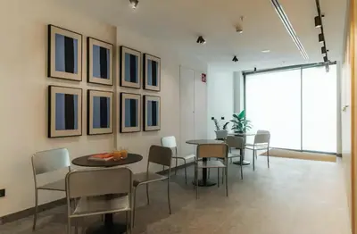 a dining room with tables and chairs and a large window at Lixar's apartment in Hospitalet de Llobregat