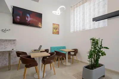 a waiting room with tables and chairs and a tv at Hotel Plini in Hospitalet de Llobregat