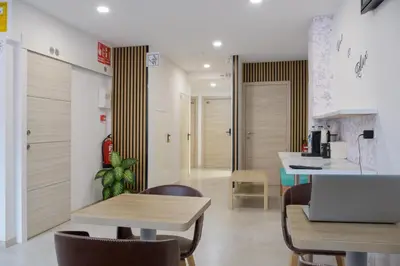 a kitchen with a table and chairs and a laptop at Hotel Plini in Hospitalet de Llobregat