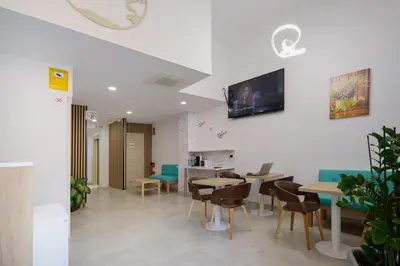 a restaurant with tables and chairs and a tv on the wall at Hotel Plini in Hospitalet de Llobregat