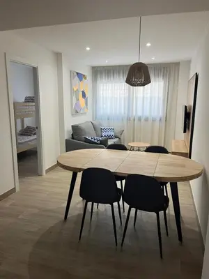 a dining table and chairs in a living room at Tr3sor B2 in Calella