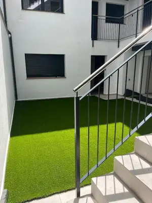 a balcony with green grass in a building at Tr3sor B2 in Calella