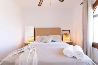a bedroom with a large white bed with towels on it at Villa Carmen - Peaceful Eco-Luxury with private pool in Cunit