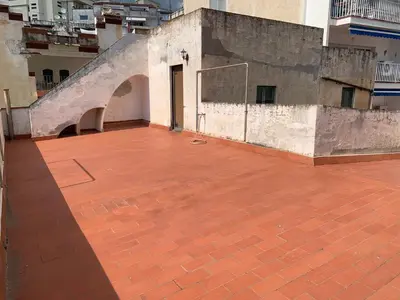 an empty courtyard with a door on a building at Casa l'àvia - Sant Pol de Mar in San Pol de Mar