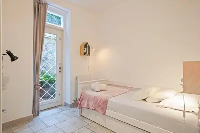 a white bedroom with a bed and a window at Winahost Apartament Cirerer in Valldoreix