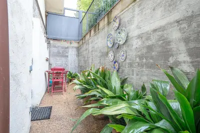 a courtyard with a red chair and some plants at Winahost Apartament Cirerer in Valldoreix
