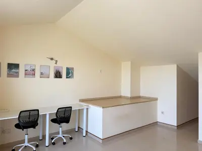 a white office with two chairs and a desk at Dúplex con encanto en Castelldefels in Castelldefels