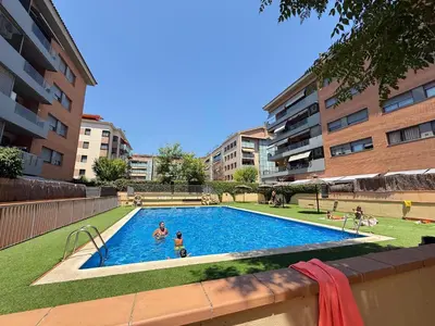 a swimming pool in a city with people playing in it at Dúplex con encanto en Castelldefels in Castelldefels