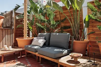 an outdoor patio with tables and chairs and potted plants at Tenere - 1 bedroom and pool in Gràcia in Barcelona