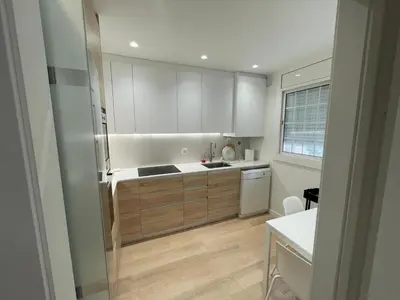 a kitchen with white cabinets and a refrigerator at Habitación Winahost Sant Cugat in Sant Cugat del Vallès