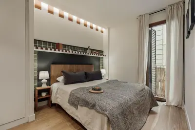 a bedroom with a bed and a desk with a desk at Mawun - 2 bedrooms in Gràcia in Barcelona